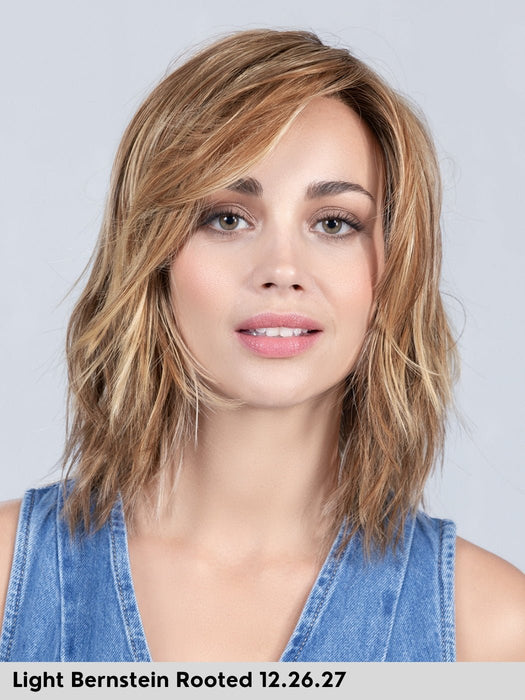 Parrucca sintetica resistente al calore mossa. Flow by Ellen Wille Perucci color light bernstein rooted. Parrucca donna bionda con radici castane.